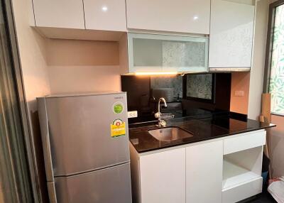 Modern kitchen with stainless steel refrigerator and black countertop