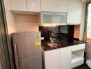 Modern kitchen with stainless steel refrigerator and black countertop