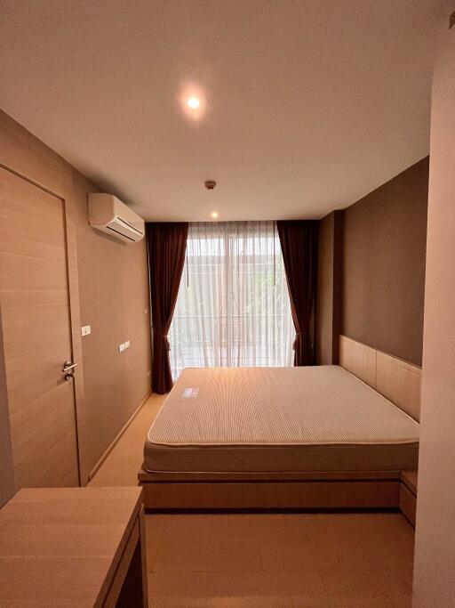 Modern bedroom with large window and brown curtains