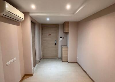 A photo of a hallway with wooden flooring and a closed door.