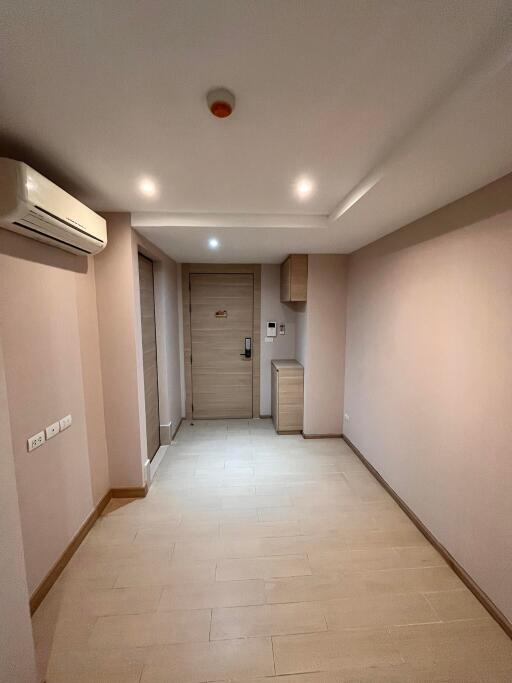 A photo of a hallway with wooden flooring and a closed door.