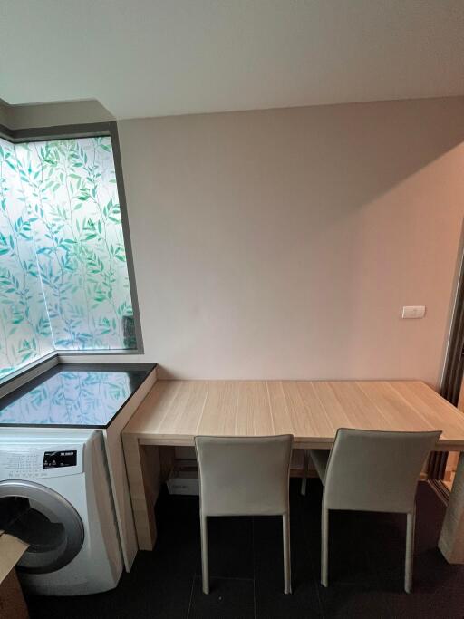 small dining area with table, two chairs, and a washing machine