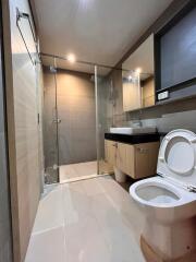 Modern bathroom with glass shower, toilet, and sink