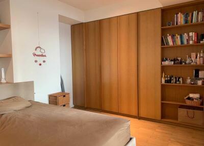 Cozy bedroom with wooden wardrobe and bookshelf