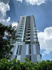 High-rise residential building under a blue sky with clouds