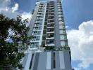 High-rise residential building under a blue sky with clouds