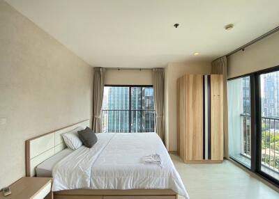 Spacious Bedroom with Large Windows and Balcony View