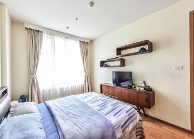 Bright and modern bedroom with wall-mounted shelves and TV