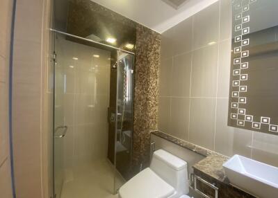 Modern bathroom with glass shower, tiled walls, and vanity