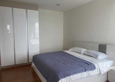 Modern minimalist bedroom with a large bed and wardrobe