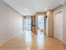 Living area with hardwood floors, air conditioning, large windows, and view of the kitchen space