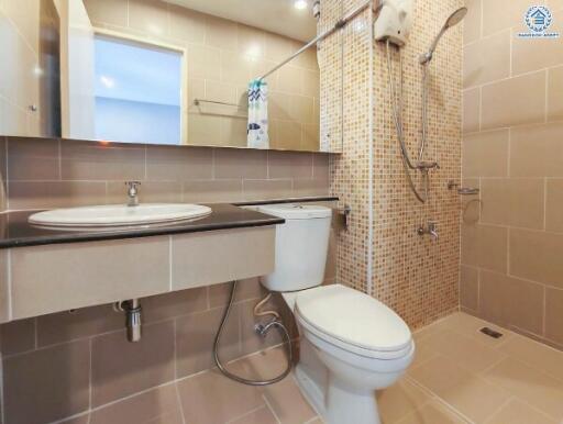 Modern bathroom with a large mirror, sink, toilet, and walk-in shower