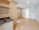 Modern kitchen and living area with wooden flooring and mosaic backsplash