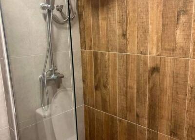 Modern bathroom shower area with wood-like tiles