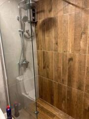 Modern bathroom shower area with wood-like tiles