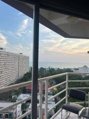 balcony with a view of the cityscape and ocean at sunset