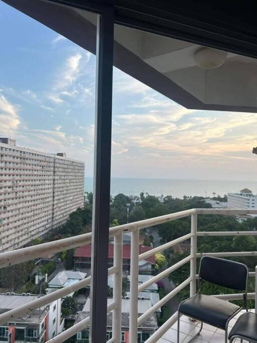 balcony with a view of the cityscape and ocean at sunset