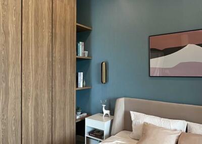 Modern bedroom with wooden wardrobe, blue accent wall, and double bed