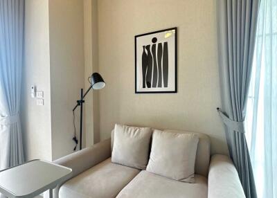 Modern living room with sofa, side table, floor lamp, and framed artwork