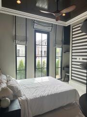 Bedroom with large windows, striped wall, and modern decor