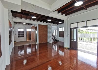 Spacious living area with wooden floors and exposed ceiling beams