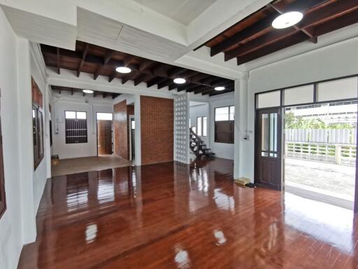 Spacious living area with wooden floors and exposed ceiling beams