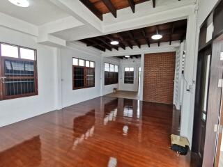 Spacious living room with wooden floors and exposed brick wall