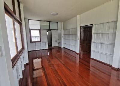 Living space with large windows, wooden floors, and built-in shelves.