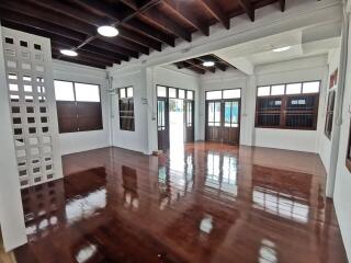 Spacious living room with large windows and polished wooden floor