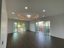 Spacious living room with large windows and chandelier