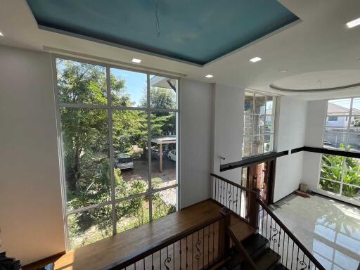 Spacious living area with large windows and high ceiling