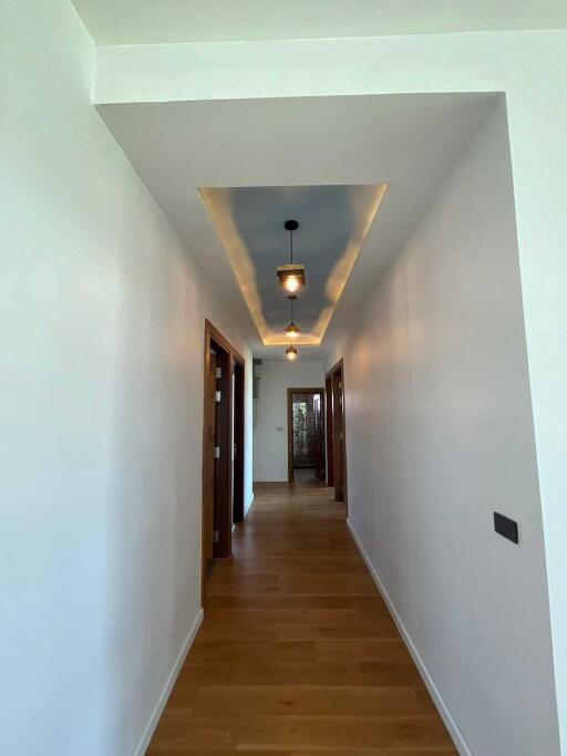 Well-lit hallway with wooden flooring