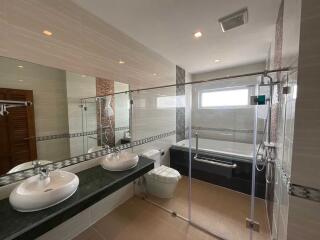 Modern bathroom with double sink, glass shower and bathtub