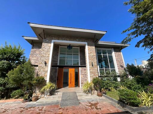 Front view of a modern house with large windows and a wooden door