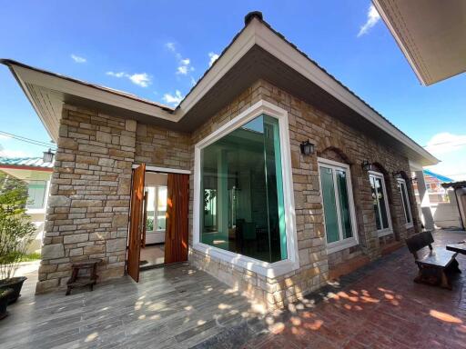 Front view of a stone exterior house with large windows