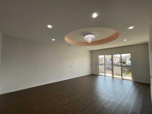 Spacious main living area with wooden flooring and a chandelier