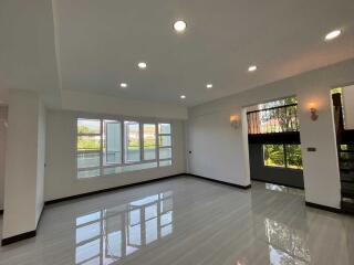 Spacious and well-lit living area with large windows and modern lighting