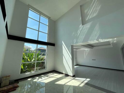 Spacious living room with large windows and high ceiling