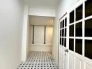 Bright hallway with patterned tile flooring and a door with glass panes