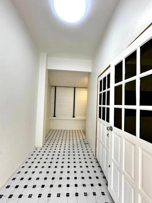 Bright hallway with patterned tile flooring and a door with glass panes