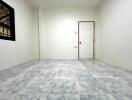 Empty bedroom with tiled floor and white door