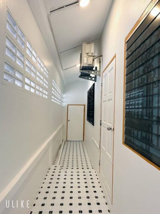 Hallway with white walls and tiled floor