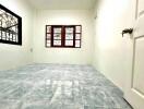Spacious empty bedroom with tiled floor and large windows