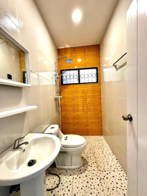 Modern bathroom with white sink, toilet, and shower