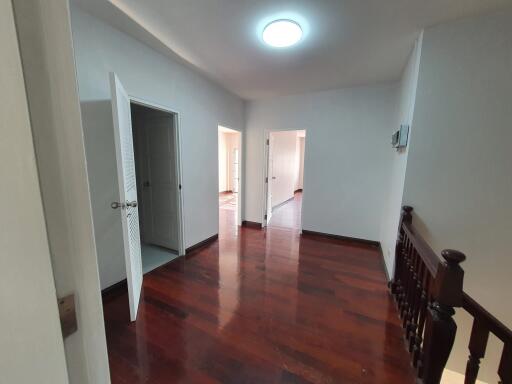 Hallway with wooden flooring leading to multiple rooms