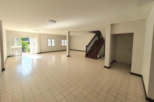 Spacious and well-lit living room with stairs