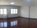 Spacious living room with wooden flooring and natural light