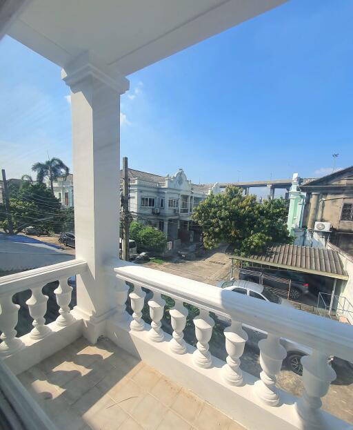 view from the balcony with white balustrades and nearby buildings