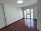 Spacious living room with wooden flooring and large windows