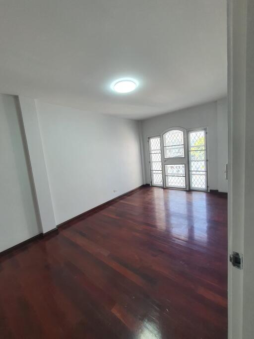 Spacious living room with wooden flooring and large windows